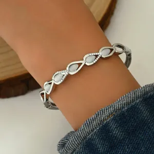 Primo piano dettagliato dell'elegante bracciale geometrico in metallo con strass a goccia.
