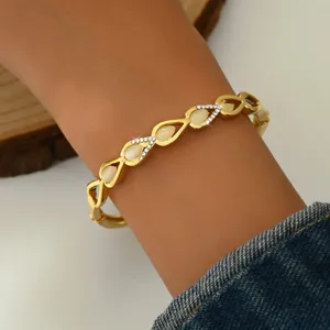 Bracciale rigido geometrico cavo placcato in oro con strass, elegante gioiello in pietra.