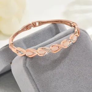 Dettaglio del bracciale geometrico in oro rosa con pietre rosa e strass brillanti.