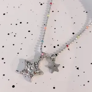 Gros plan d'un collier pendentif étoile argenté bouffant avec des perles colorées et des strass.