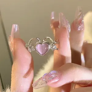 Detailaufnahme des süßen rosafarbenen Herz Katzenauge Rings mit eleganten funkelnden Kristallen.
