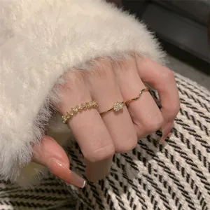 Dettaglio ravvicinato del delicato set di tre anelli con cuore brillante e fasce eleganti.