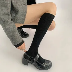 Gedetailleerd overzicht van zwarte geribbelde sokken gecombineerd met retro schoenen voor college.