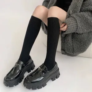 Detailopname van zwarte plateau schoenen gecombineerd met zwarte geribbelde sokken.