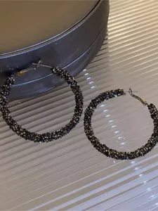 Gros créoles scintillantes en strass, détail de bijoux tendance pour femmes élégantes.