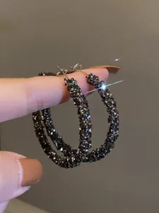 Boucles d'oreilles créoles scintillantes en strass foncé vue détaillée mode femme.