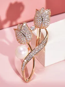 Dettaglio di una lussuosa spilla a forma di tulipano con strass e perla, gioiello elegante donna.