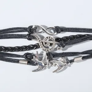 Handgemachte mehrschichtige schwarze Lederseilarmband mit detaillierten Metallanhängern.