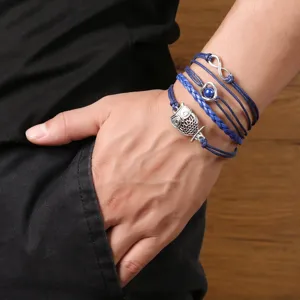 Nahaufnahme des mehrschichtigen blauen Lederarmbands mit niedlichen Anhängern.