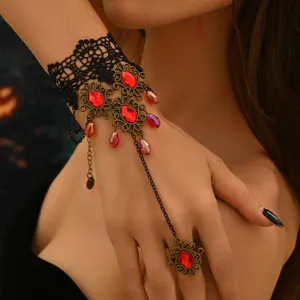 Bracelet esclave en dentelle gothique avec bague reliée, cristaux rouges et chaîne métal.