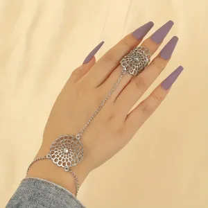 Delicat bracelet de main argente avec bague, design floral evide pour style de mode feminin.