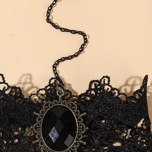 Gros plan sur le bracelet de main en dentelle noire avec pendentif en pierre précieuse.