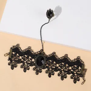 Vue détaillée du bracelet esclave en dentelle noire gothique avec chaîne bronze et bague pierre.