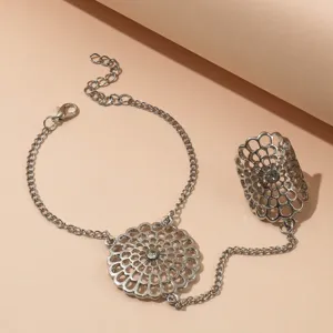 Gros plan détaillé sur le bracelet d'esclave en métal argenté au design floral ajouré.
