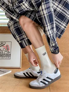 Chaussettes mi-hautes homme en coton avec design brodé de lettres type et bande élastique.