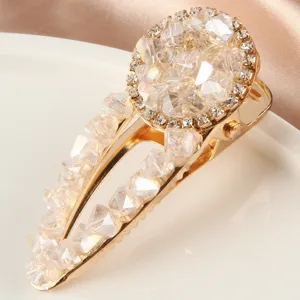 Gros plan détaillé de l'élégante pince à cheveux en cristal doré ornée de strass.