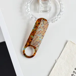 Acetate hair comb detail view, anti-static tortoiseshell pattern with convenient circular handle.