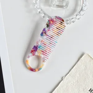 Colorful acetate comb detail view, stylish marble pattern hair comb with round handle design.
