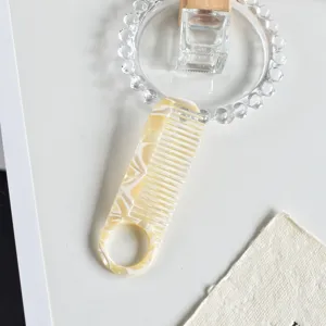 Acetate hair comb with elegant marble pattern, anti-static styling tool with round handle.