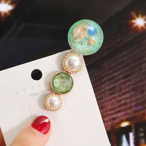 Detailed view of the Korean style macaron candy color hair clip with pearl and planet decor.