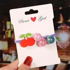 Cute cartoon cherry hair tie with shiny beads on display card, perfect for kids daily wear.