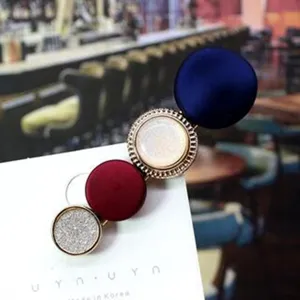Close-up detail of stylish Korean hair clip with velvet buttons and rhinestone metal rings.