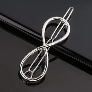 Silver metal hair clip, minimalist infinity shape hairpin, sleek metallic finish detail view.