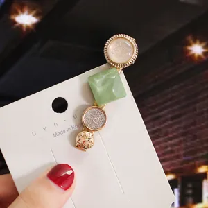 Exquisite multi-element hair clip detail showcasing geometric green resin and pearls.