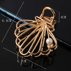 Gold seashell metal hair claw clip with pearl, large hair accessory for elegant hairstyles.