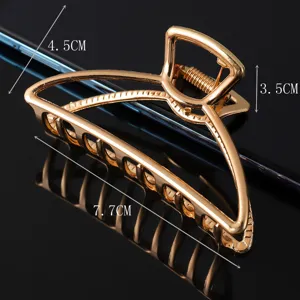 Detailed view of the gold geometric metal hair claw clip, showcasing its size and alloy design.