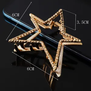 Gold star hair claw clip detail view, featuring textured metal design and compact size.