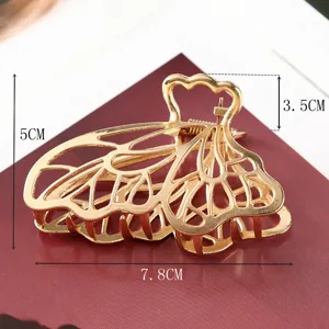 Gold metal hair claw clip with butterfly wing design, large elegant hair accessory for women.