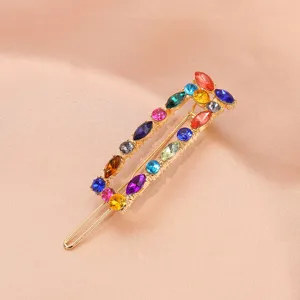 Close-up detail of colorful rhinestone hair clip, elegant sparkling crystal decorative barrette.
