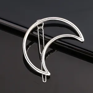 Detail shot of a silver crescent moon metal hair clip, sleek geometric barrette for women.