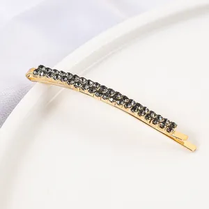 Detailed view of a golden double-row rhinestone bobby pin, stylish hair accessory for women.