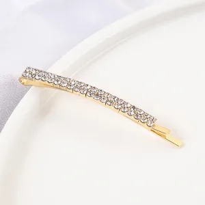 Rhinestone bobby pin detail view showing glittering crystal double rows on a polished gold clip.