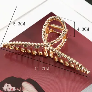 Gold metal hair claw detail showing dimensions, twisted design for elegant hair styling.