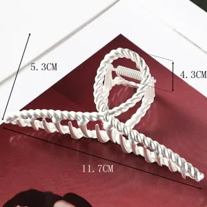 Large metal hair claw clip with twisted design, elegant hair styling accessory for women.