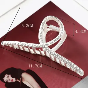 Large metal hair claw clip with unique geometric design and textured finish for elegant styling.