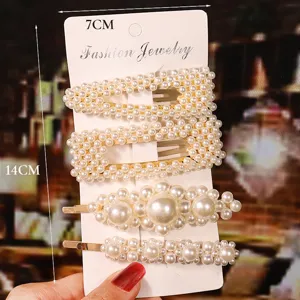 Detailed view of elegant pearl hair clip set with delicate artificial pearls on gold metal.