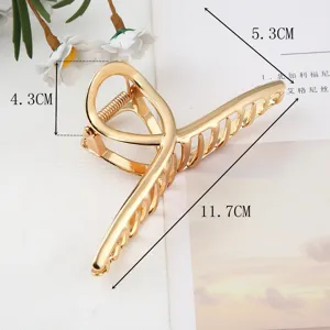 Large gold metal hair claw clip for women, elegant hollow geometric design for styling.