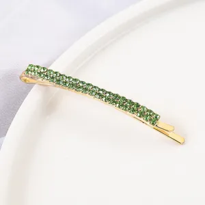 Detailed view of a Korean style double row rhinestone hair clip, sparkling green bobby pin.