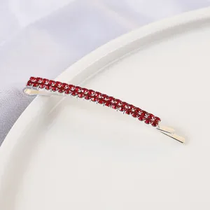 Close-up view of the double-row red rhinestone bobby pin, showing sparkling crystal details.