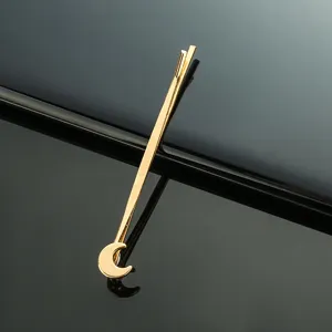 Détail épingle à cheveux métal doré, design croissant de lune élégant et accessoire.