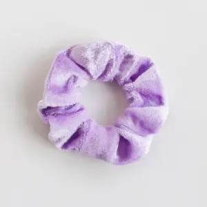 Gros plan d'un chouchou en velours violet doux, montrant sa texture riche et son élastique.