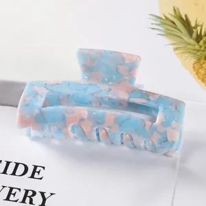 Détail de grande pince à cheveux en acétate acrylique, griffe élégante bleue rose écaille.