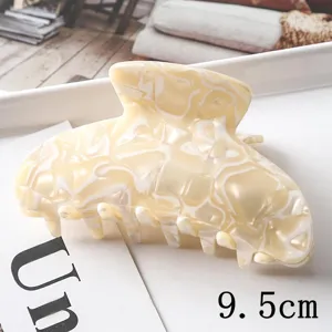Vue en gros plan détaillée de l'élégante pince à cheveux en acrylique marbré et sa taille.