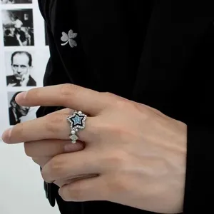 Close-up detail of the star-shaped ring featuring blue enamel, rhinestones and delicate pearls.