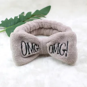 Detailaufnahme des Flanell Stirnbandes, weiches Pluesch Schleifendesign mit gestickten Buchstaben