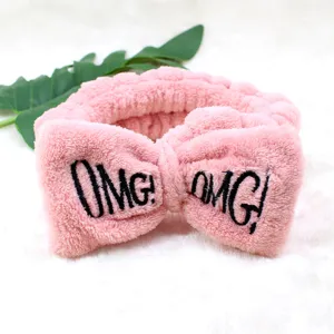 Detailaufnahme des rosa flauschigen Stirnbandes mit großer Schleife und OMG-Stickerei.